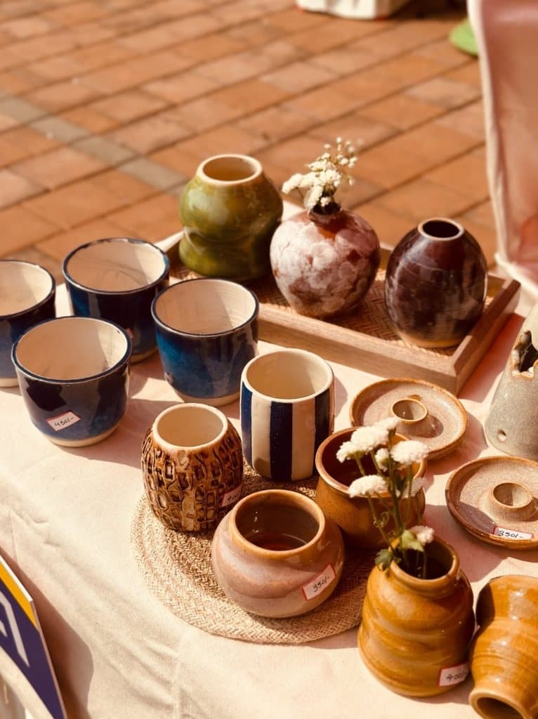 Studio table display with cups, bud vases, and planters